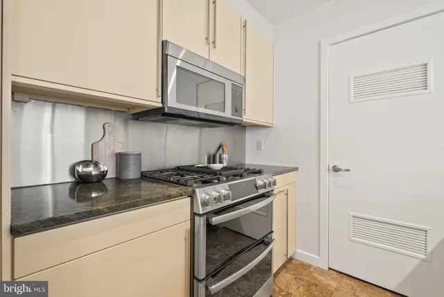 a kitchen with stainless steel appliances granite countertop a stove and a microwave