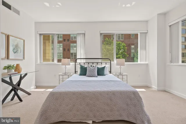 a bedroom with a bed chair and next to a window