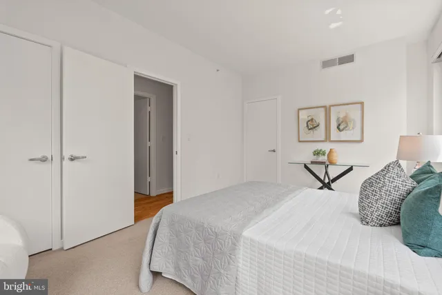 a bedroom with a bed and painting on the wall