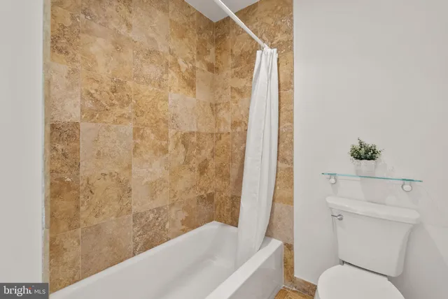 a bathroom with a toilet and a shower