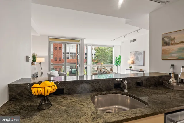 a kitchen with a sink and a view of living room