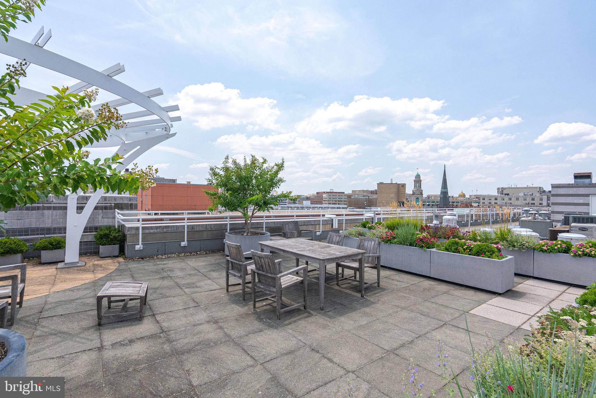 1300 13th Street Northwest, Unit 408 Washington, DC 20005 - Photo 41 of 47 a view of a patio with a table and chairs and potted plants
