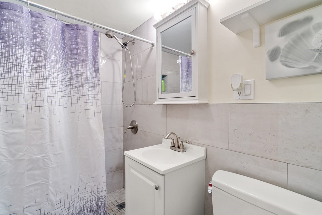 194 Lexington Street, Unit 1 Watertown, MA 02472 - Photo 9 of 10 a bathroom with a sink a toilet and shower curtain