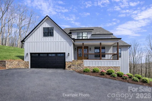 a front view of a house with a garden and yard