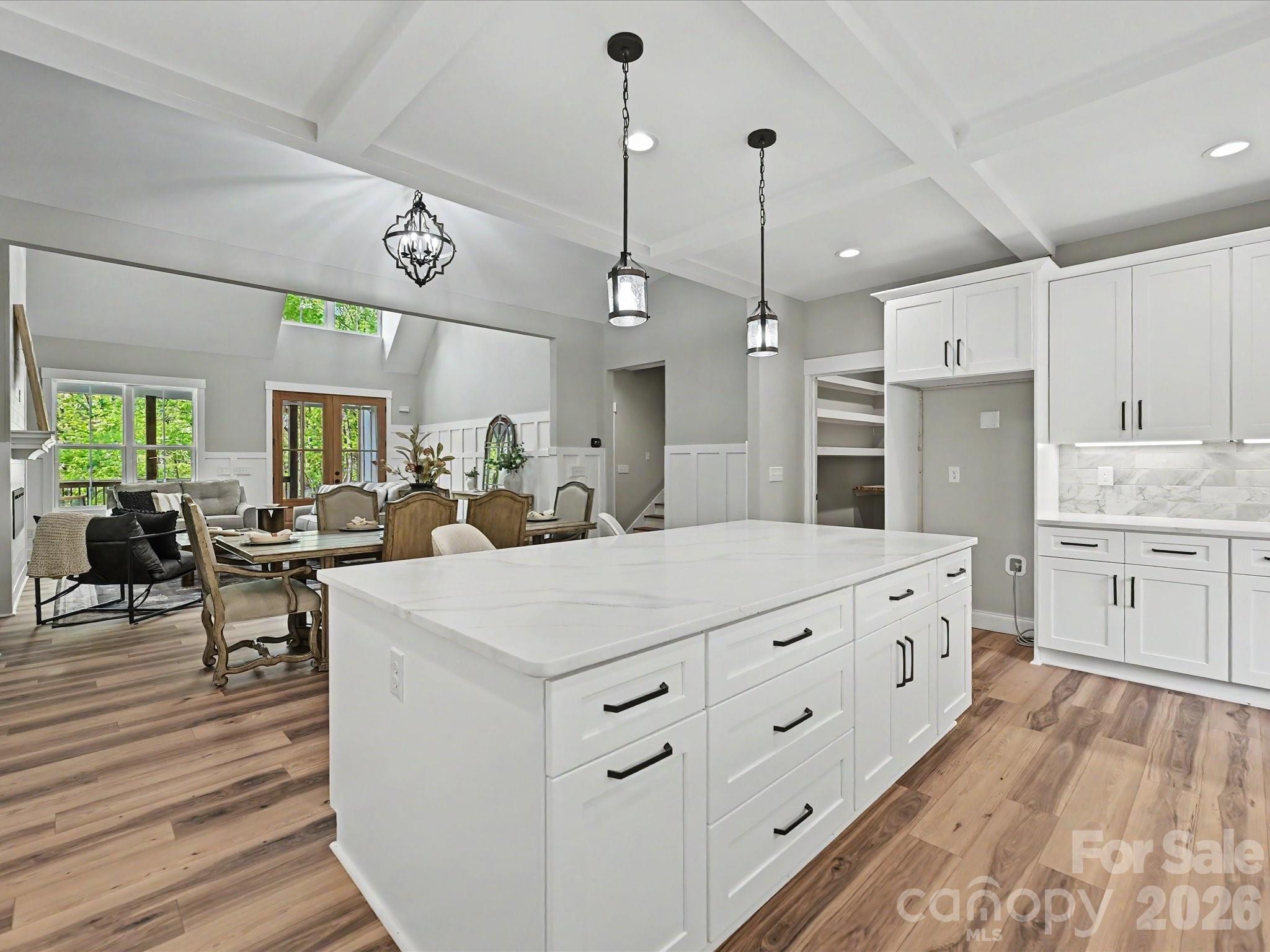 5310 West Liberty Hill Road York, SC 29745 - Photo 9 of 29 a large white kitchen with a large center island a stove a refrigerator cabinets and couches with wooden floor