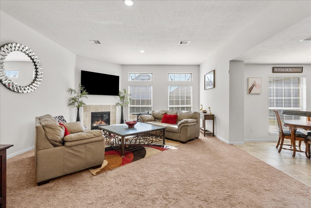 2111 Gilbert Road League City, TX 77573 - Photo 15 of 38 The living room features a cozy fireplace and is bathed in natural morning light through an abundance of windows