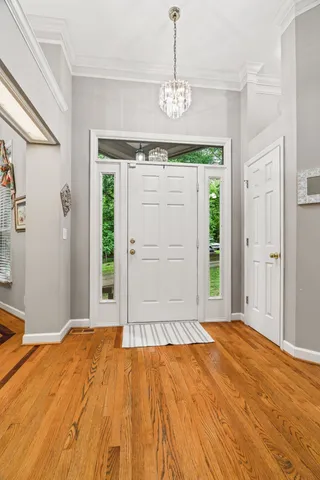 a view of a dining room with furniture wooden floor and chandelier