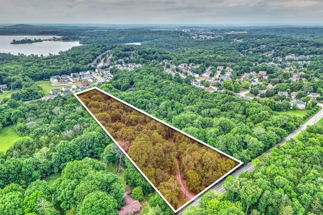 an aerial view of residential house with outdoor space and trees all around