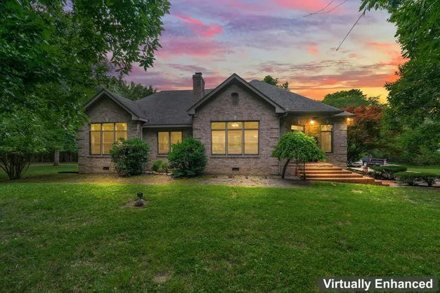 a front view of a house with a yard and trees