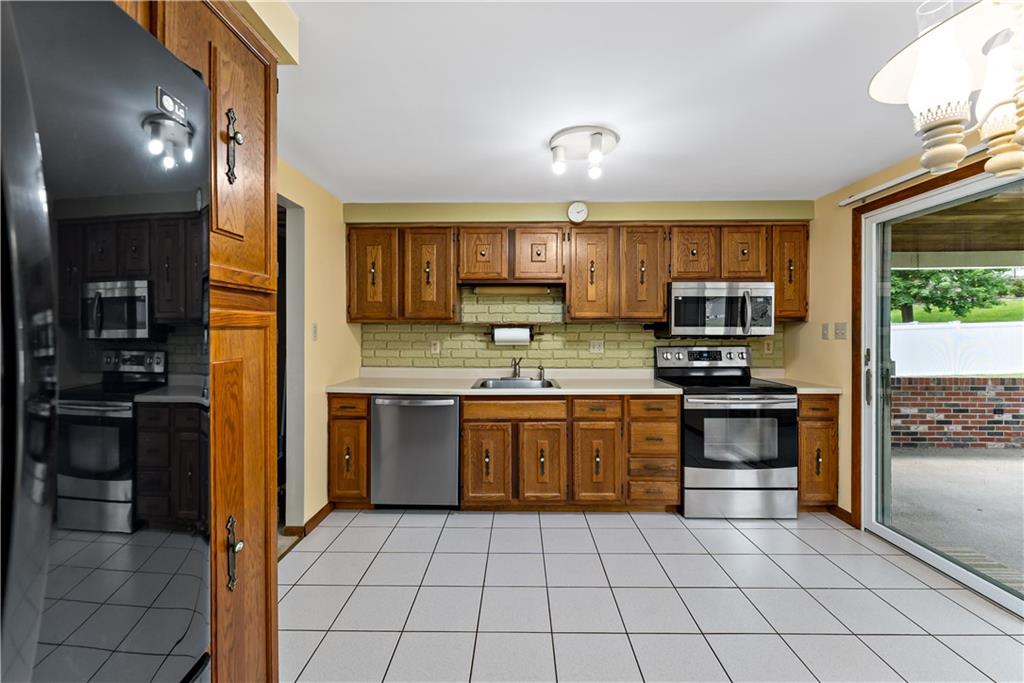 27 Dover Road Irwin, PA 15642 - Photo 9 of 43 a kitchen with stainless steel appliances granite countertop a stove top oven a sink and a refrigerator