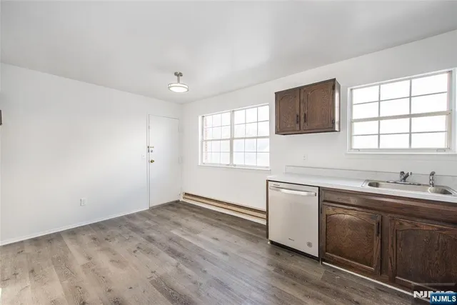 a kitchen with a sink wooden floor and window