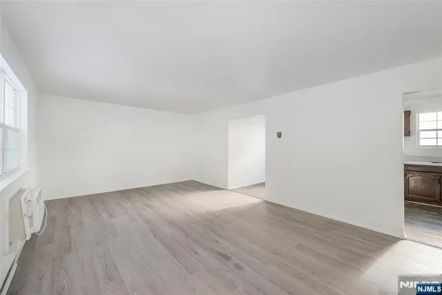 an empty room with wooden floor and a window