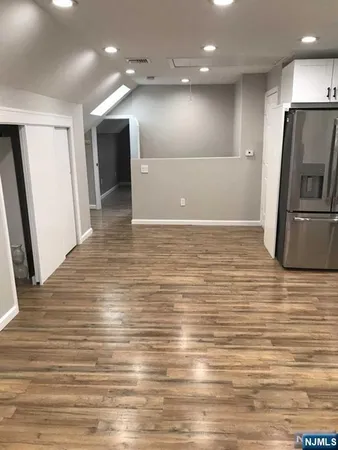 a view of a refrigerator in kitchen and a wooden floor