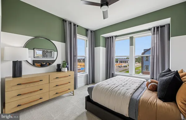 a bedroom with a bed a dresser and a chandelier