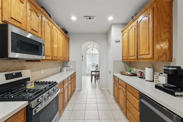 a kitchen with stainless steel appliances a sink stove and cabinets