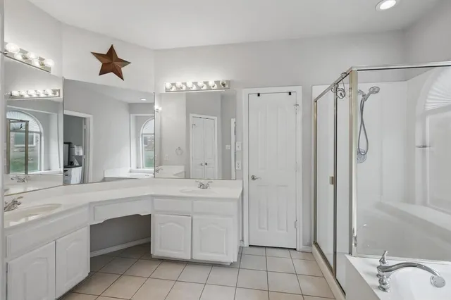 a spacious bathroom with a shower a sink and a mirror