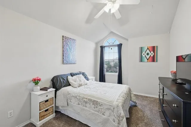 a bedroom with a bed and a flat tv screen on dresser