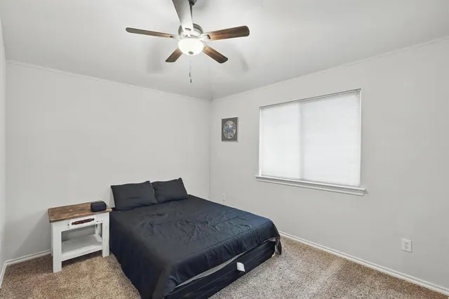 a bedroom with a bed and a ceiling fan