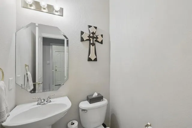 a bathroom with a toilet sink and mirror