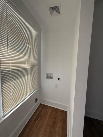 a view of a small space with wooden floor and a window