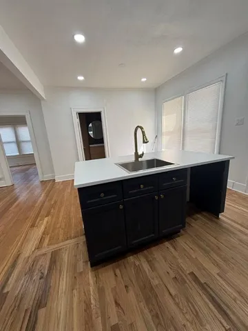 a kitchen with a sink and wooden floor