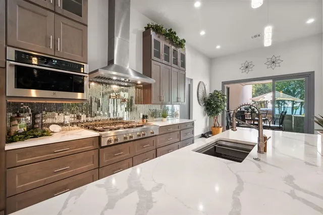 a large kitchen with stainless steel appliances granite countertop a stove and a sink