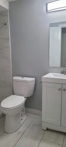 a white toilet sitting next to a bathroom sink