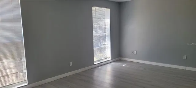 a view of an empty room with wooden floor