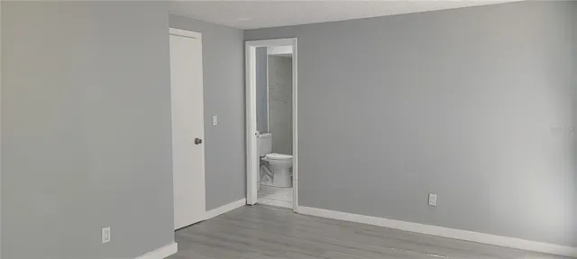 a white toilet sitting next to a white sink and vanity