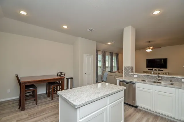 a kitchen with a sink cabinets and wooden floor
