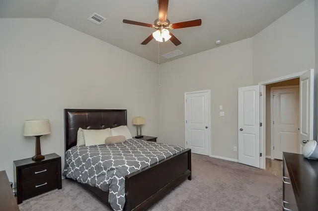 a bedroom with a bed and a lamp on the dresser
