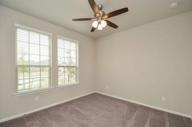 an empty room with a window and a fan