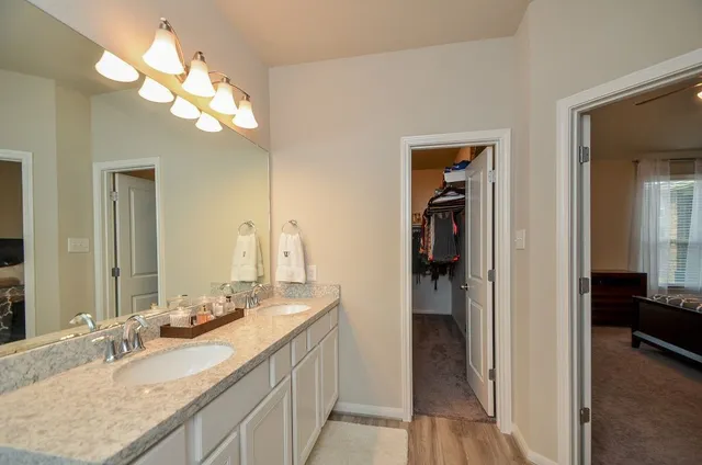 a bathroom with a granite countertop sink a light fixture and a mirror