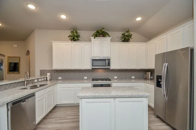 a kitchen with stainless steel appliances a sink stove and refrigerator