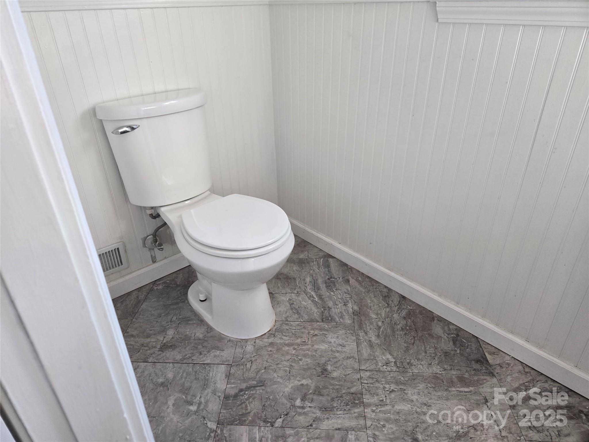 7214 Fox Hunt Road Charlotte, NC 28212 - Photo 17 of 24 a white toilet sitting in a bathroom