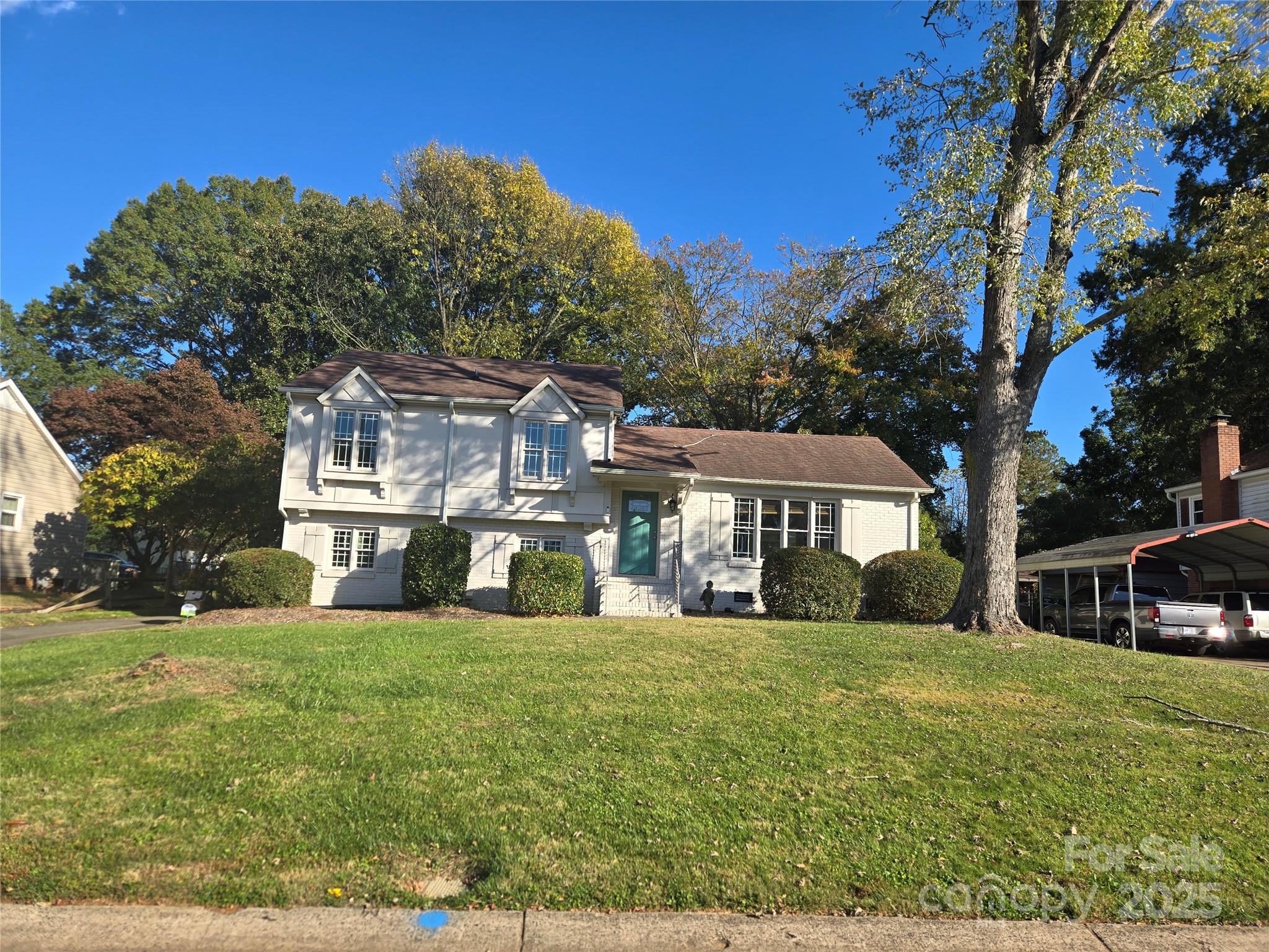 7214 Fox Hunt Road Charlotte, NC 28212 - Photo 2 of 24 a view of a white house with a big yard and large trees