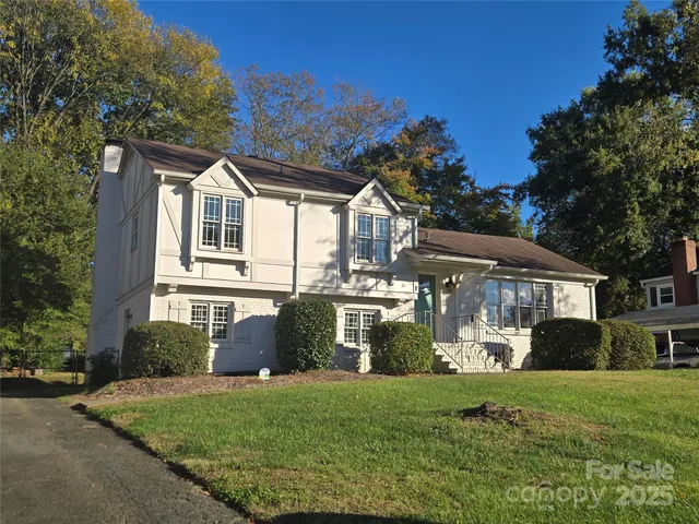 a front view of a house with a yard and trees