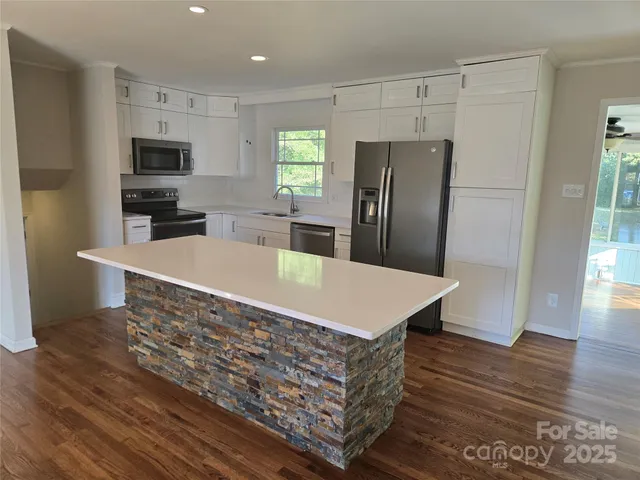 a kitchen with stainless steel appliances a refrigerator and wooden floor