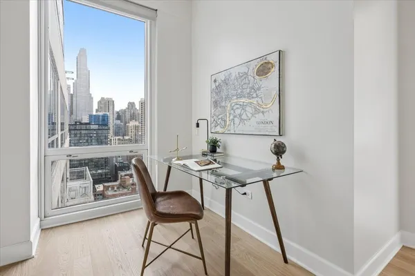 a view of a workspace with furniture and a window