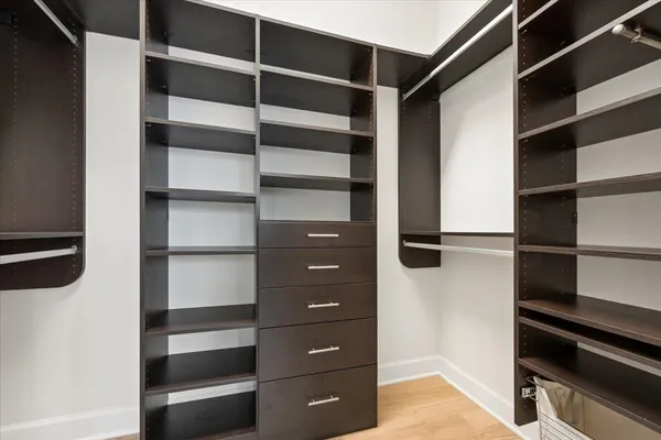 a view of walk in closet with empty racks