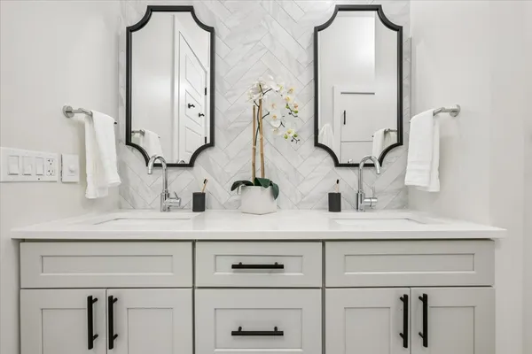 a bathroom with vanity sinks and a mirror