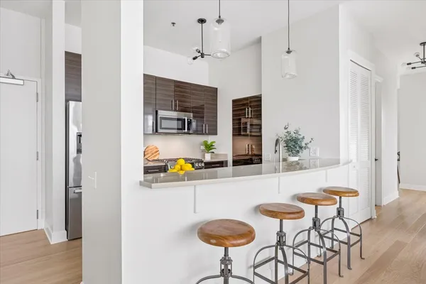 a kitchen with stainless steel appliances granite countertop a sink and a refrigerator