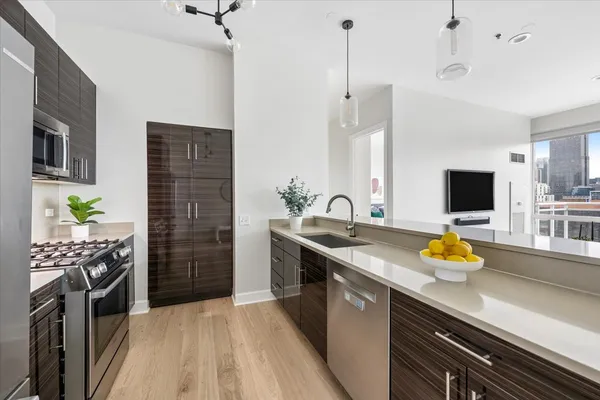 a kitchen with stainless steel appliances kitchen island granite countertop a sink stove and refrigerator