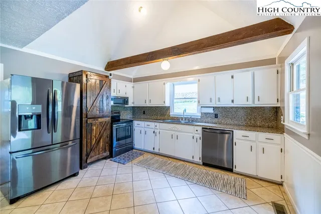 a kitchen with granite countertop a refrigerator and a stove top oven