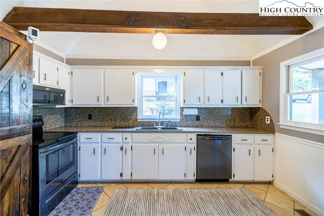 a kitchen with stainless steel appliances granite countertop a stove a sink and a white cabinets