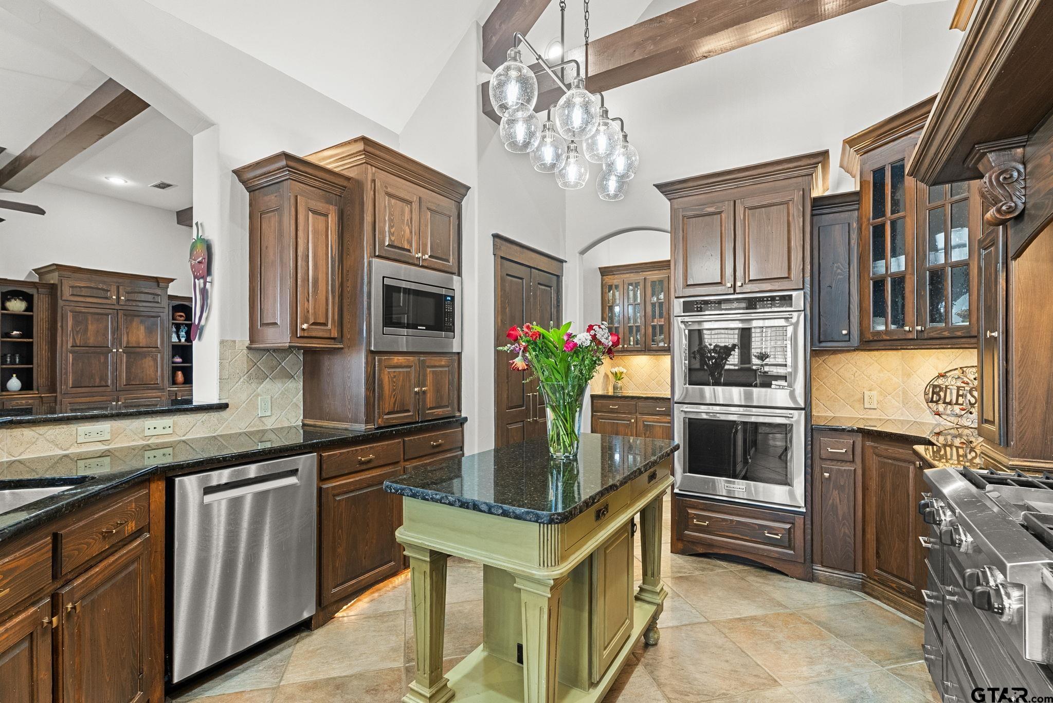 2306 Kingsmill Circle Tyler, TX 75703 - Photo 10 of 37 a kitchen with stainless steel appliances granite countertop a stove refrigerator and cabinets