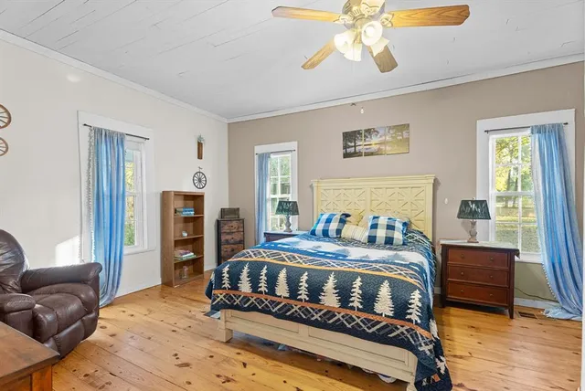 a bedroom with a bed and wooden floor