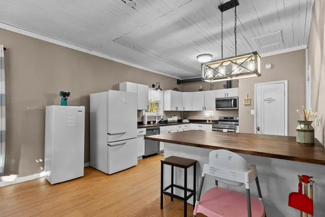 a kitchen with refrigerator cabinets and wooden floor