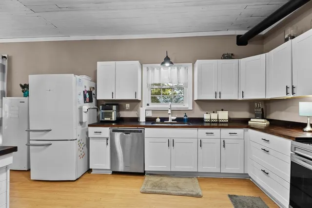 a kitchen with white cabinets and white appliances
