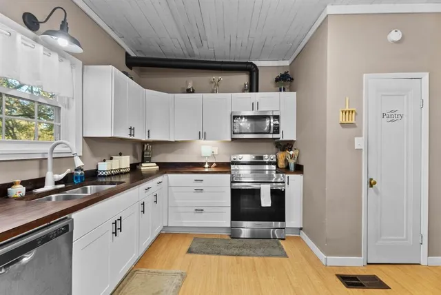 a kitchen with stainless steel appliances granite countertop a sink stove and cabinets